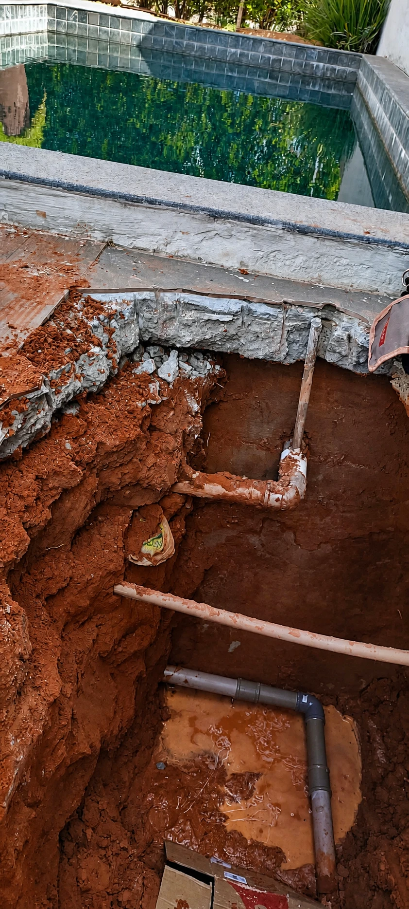 Tubulação exposta ao lado de uma piscina